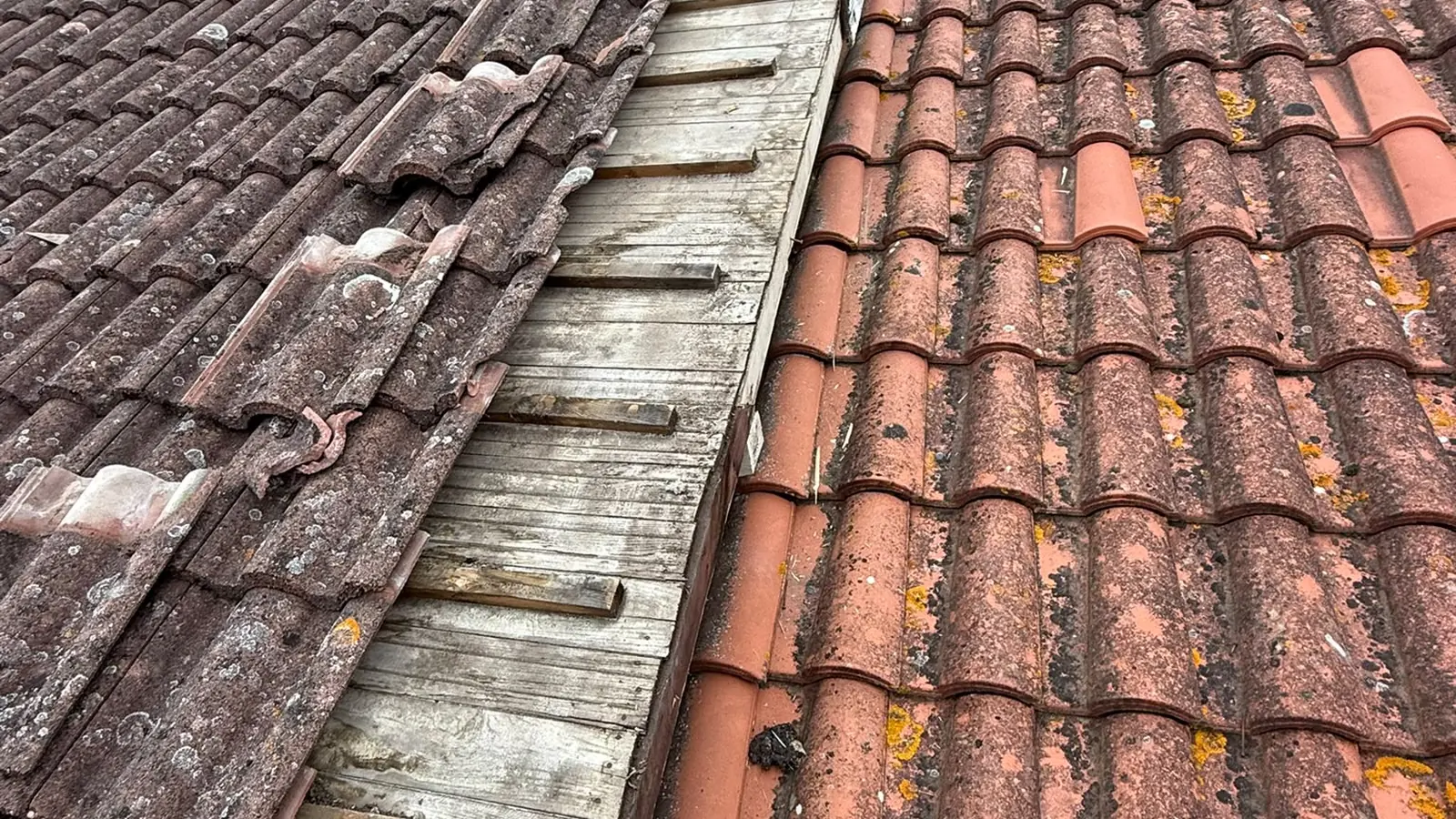 Noue ancienne et encombrée entre deux pans de tuiles